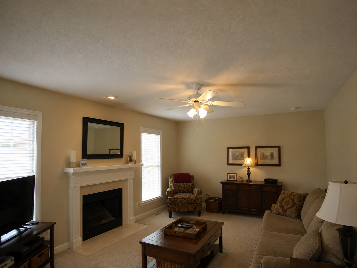 Before South Charlotte living room renovation with beige walls, carpet, and minimal detailing