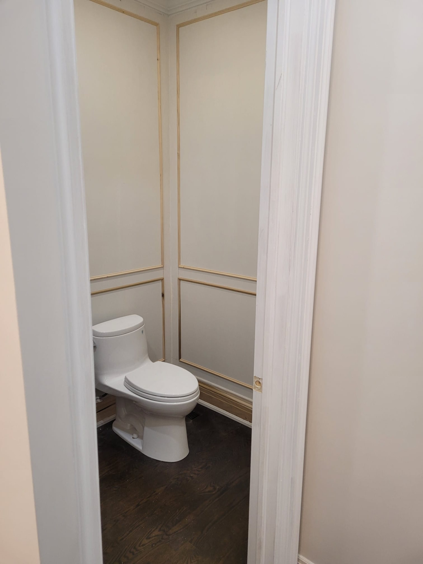 Before photo of a Huntersville NC powder room with unfinished white wall moulding awaiting trim and paint