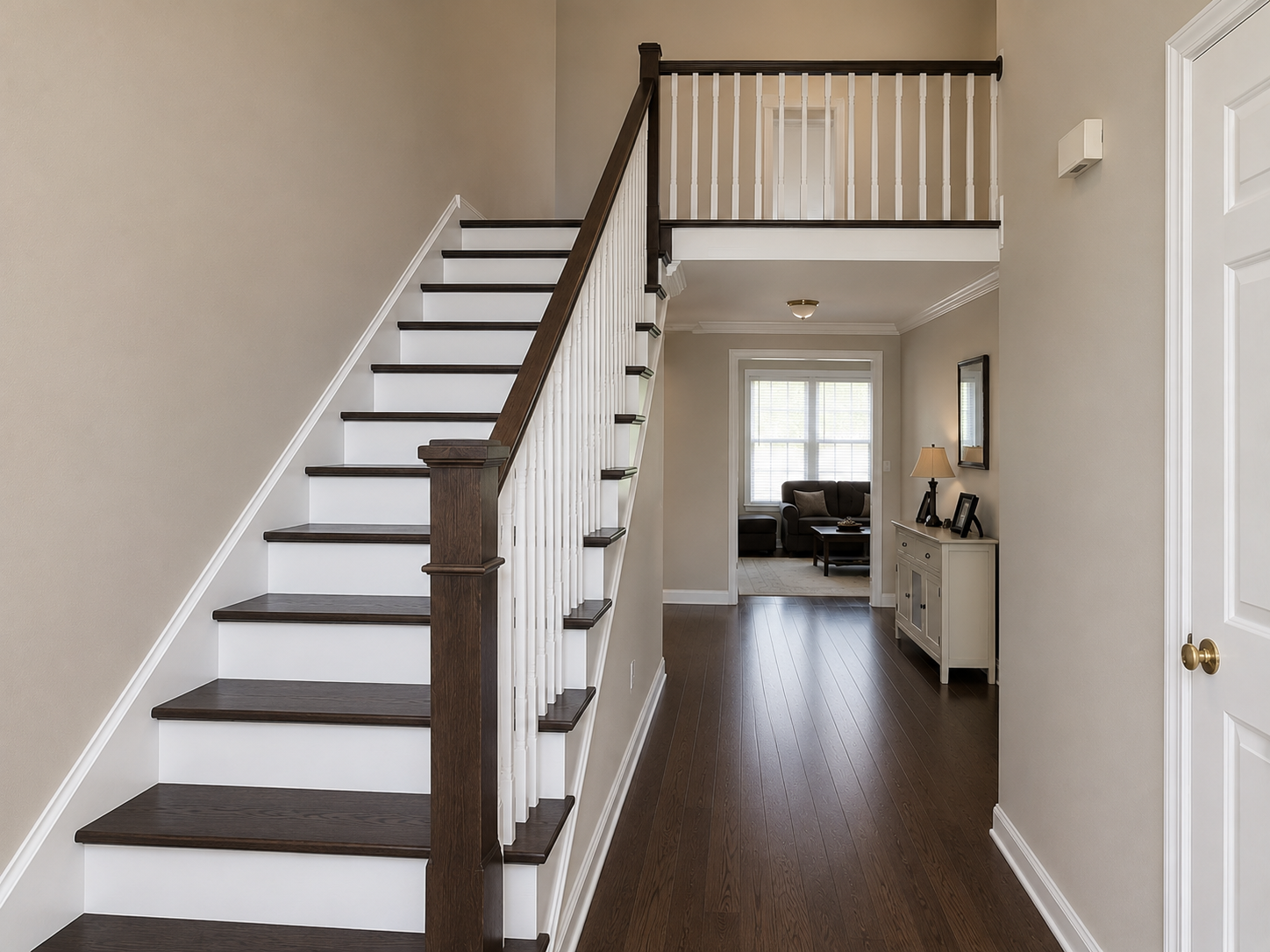 After photo of Ballantyne staircase and foyer with dark stained treads, white risers, and refinished floors
