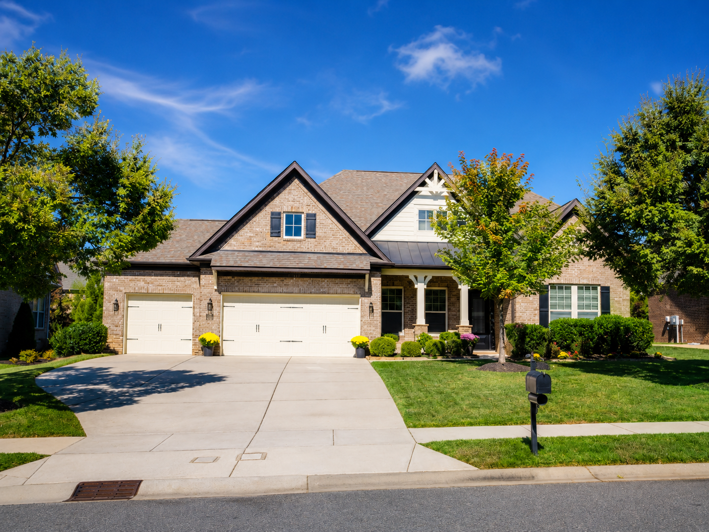 After exterior painting photo of Charlotte brick home with darker refreshed trim and garage doors