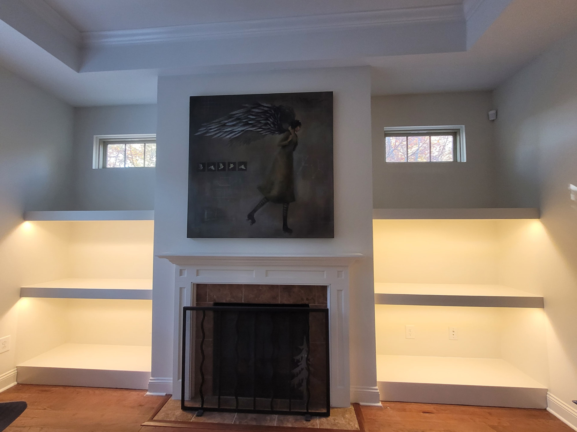 After photo of a South Charlotte fireplace wall with custom built-in shelving and integrated LED accent lighting